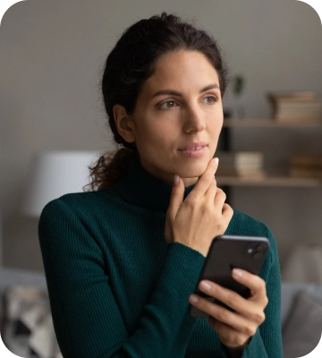 صورة لامرأة تحمل هاتفًا محمولًا